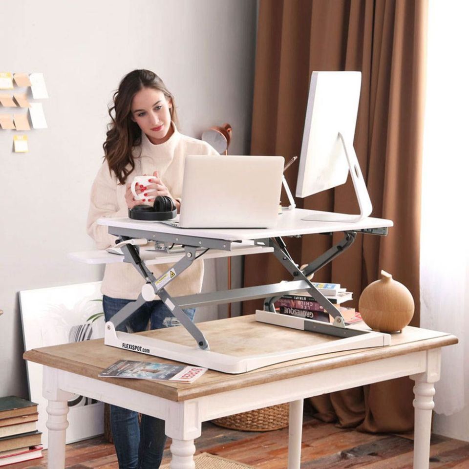 woman-using-standing-desk-with-multiple-monitors